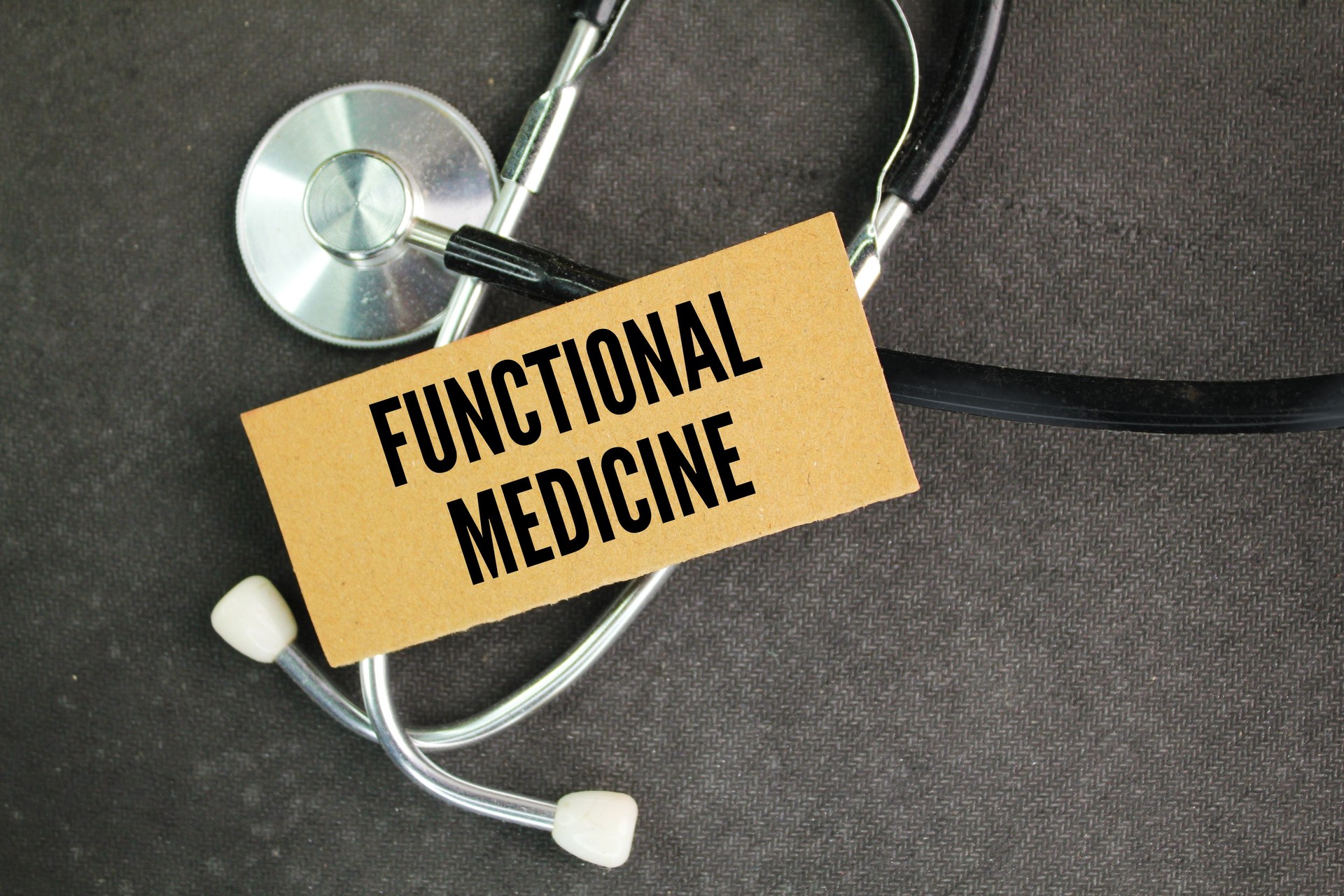 stethoscope, medicine and colored paper with the word functional medicine